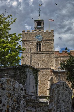 Vaftizci kilisesinin dikey görüntüsü Aziz John 'un bulutlu gökyüzünün altındaki saati.