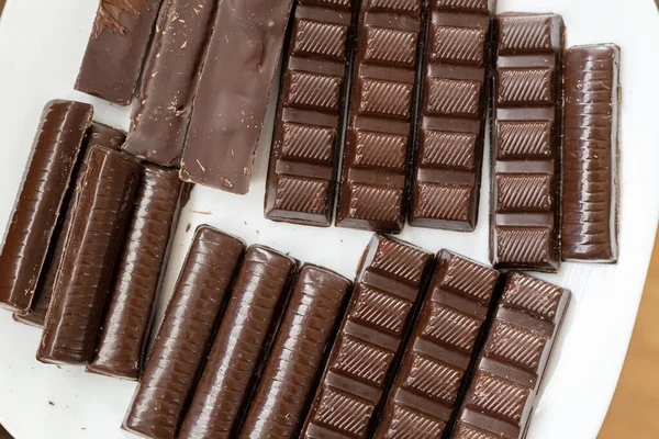 Großaufnahme Verschiedener Dunkler Schokoladentafeln Auf Einem Weißen Teller Holztisch — Stockfoto