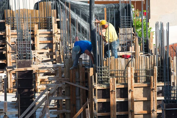 İnşaat işçileri, sıvı çimento makinesinin yardımıyla inşaat için bir ev inşa ediyorlar, Volos Yunanistan 5-26-2022