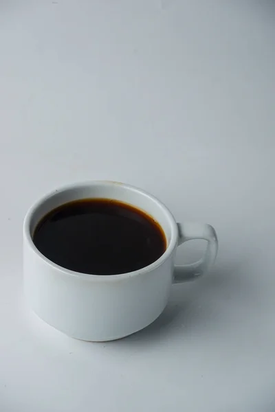 白い背景に隔離された黒いコーヒーのカップの垂直ショット — ストック写真