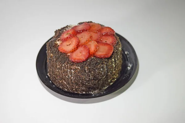 Eine Nahaufnahme Eines Kleinen Schokoladenkuchens Mit Erdbeerscheiben Auf Weißem Hintergrund — Stockfoto