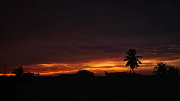 Uma Silhueta Construção Árvores Sob Céu Nublado Durante Pôr Sol — Fotografia de Stock