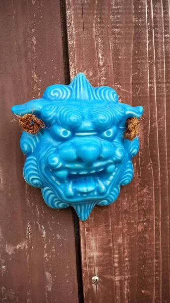木製のドアに青い伝統的な琉球シーサー文化遺産の垂直ショット — ストック写真