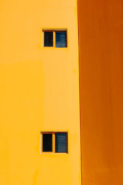 Eine Vertikale Aufnahme Der Fenster Der Gelben Und Orangefarbenen Hauswand — Stockfoto