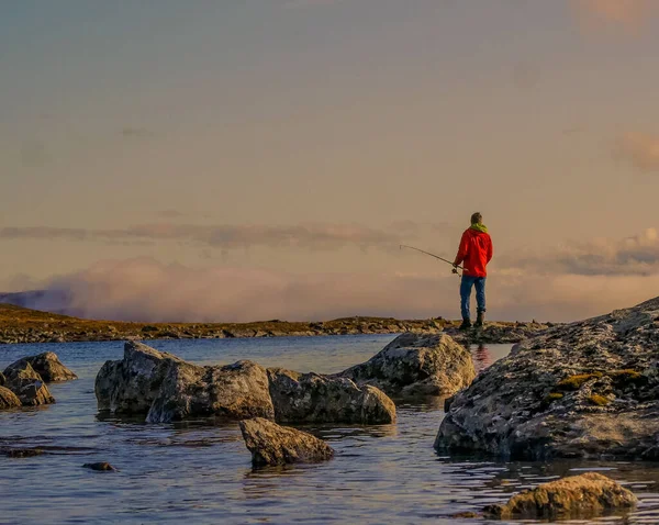 川から釣ろうとする岩の上に立つ男の後ろ姿 — ストック写真