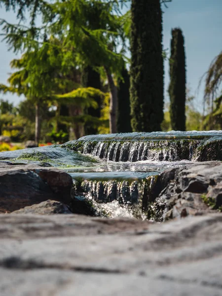 一缕垂直的水流过花园岩石的水柱 — 图库照片