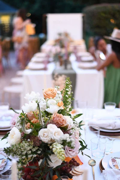 イベントのために美しく装飾されたテーブルの上にカラフルな花束の垂直ショット — ストック写真