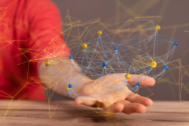 Mavi ve sarı renkli soyut bir ağ bir adamın avucunda asılı duruyor.