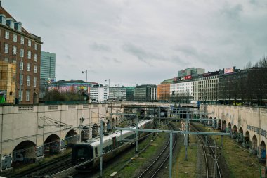 Demiryolunda arka planda binalar olan bir tren yakalandı.