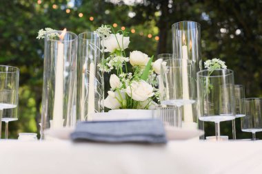 Güzel dekore edilmiş bir masa beyaz güller ve açık hava düğün için mumlar.