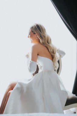 Beyaz bir kadının gelinlik giydiği dikey bir fotoğraf.
