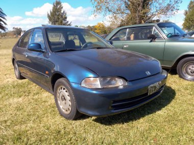 Chascomus, Arjantin - 9 Nisan 2022: Blued Honda Civic kırsal alanda dört kapılı sedan 1994. Doğa, çimen, ağaçlar. Güneşli bir gün. Klasik araba şovu..