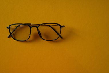 Gözlük turuncu bir arka planda izole edilmiş.