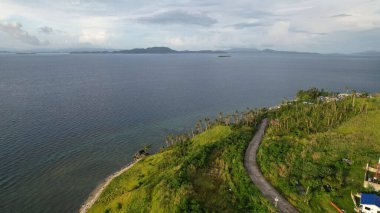 Dağ ufku bulutlarla kaplı, şehir ve yeşil orman Filipinlerin doğasının inanılmaz güzelliğini ve sanatını gözler önüne seriyor.