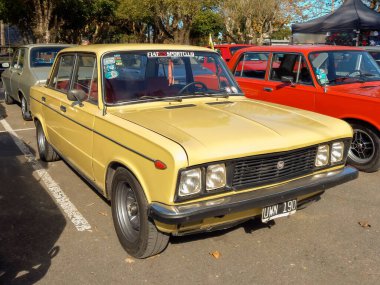 Quilmes, Arjantin - 29 Mayıs 2022: Eski sarı Fiat 125 dört kapılı sedan 1970 'ler bir parkta. Güneşli bir gün. Doğa, ağaçlar. Klasik araba şovu..