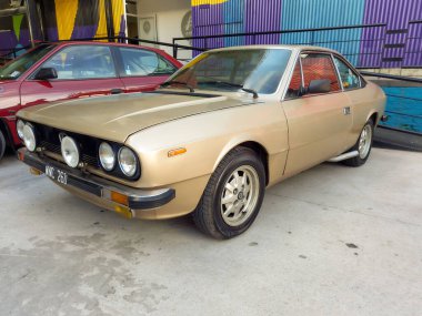 Avellaneda, Arjantin - 8 Mayıs 2022: 1970 'lerin sonlarında eski bej renkli Lancia Beta coupe bir depo avlusuna park edilmiş. Expo Fierro 2022 Klasik araba şovu.