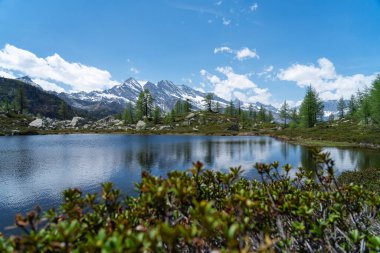 Dağların ve bulutların yansımasıyla güzel bir göl manzarası