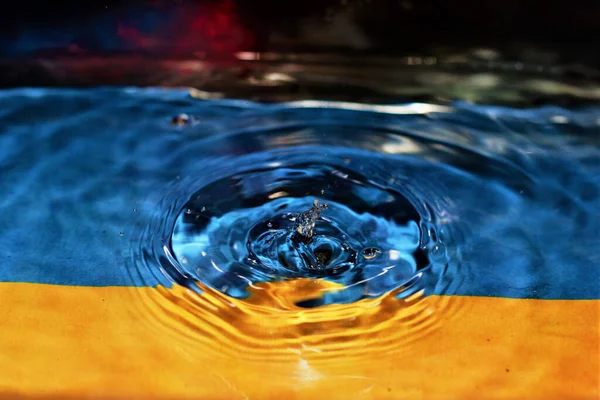 Zbliżenie Ujęcia Kropli Wody Niebiesko Żółtym Tle — Zdjęcie stockowe