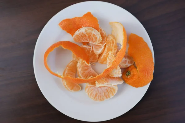 Ein Schuss Geschälte Mandarinenscheiben Mit Schalen Auf Einem Weißen Teller — Stockfoto