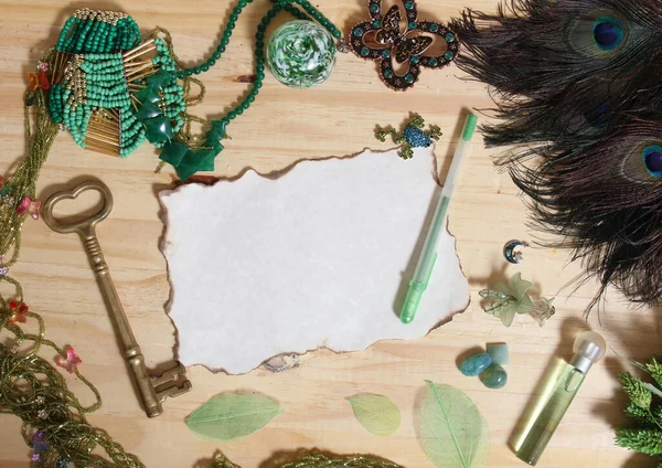 緑の宝石と木の背景に孔雀の羽に囲まれたヴィンテージ焼き紙とアンティークキー — ストック写真