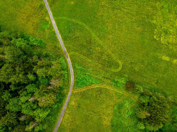 A Birds eye view of the green field trees and roads in one side