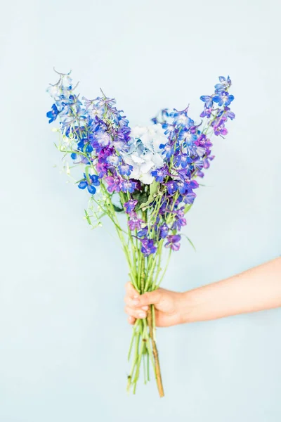 Vertical Shot Bouquet Purple Flowers Woman Hand Blue Background — Stock Photo, Image