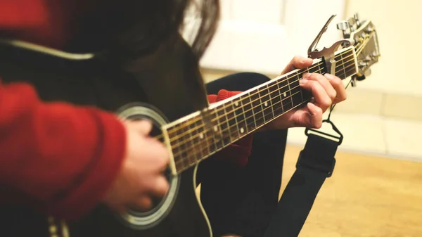 黒のアコースティックギターを弾いている人のクローズアップショット — ストック写真