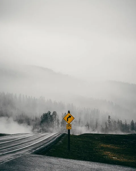 霧の日に森の道を撮影し 明るい黄色の右折標識 — ストック写真