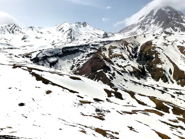 Een Besneeuwde Bergen Met Een Bewolkte Blauwe Lucht Achtergrond — Stockfoto