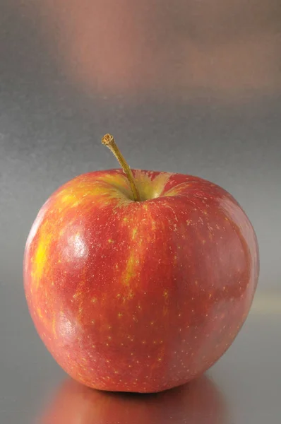 Ein Saftig Roter Apfel Vor Farbigem Hintergrund — Stockfoto