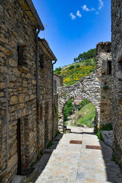 A narrow street between the old houses of Sasso di Castalda, a village in the mountains of Potenza province, Italy.