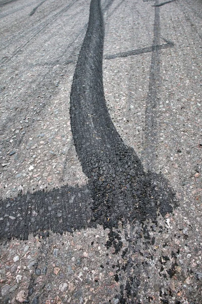 アスファルト道路上の黒いタイヤマークの垂直ショット — ストック写真