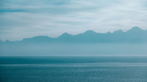 Uma Vista Panorâmica Tranquilo Lago Azul Contra Silhuetas Uma Cordilheira — Fotografia de Stock