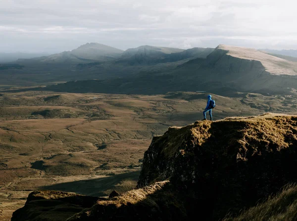 İskoçya 'nın Skye Adası' ndaki bir uçurumdan manzaraya bakan bir turistin hava görüntüsü.
