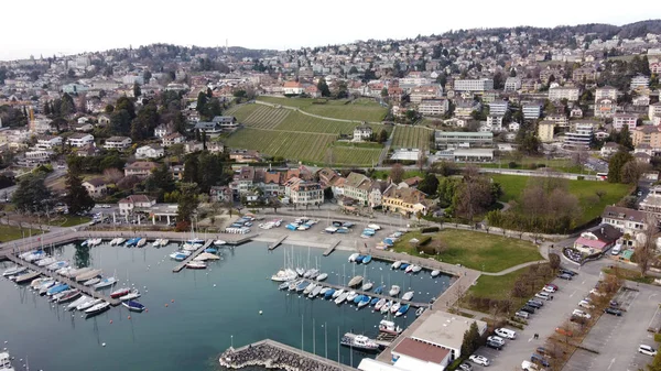 A bird\'s eye view of boats moored at the Port of Pully against the houses on the hill in Lausanne, Switzerland