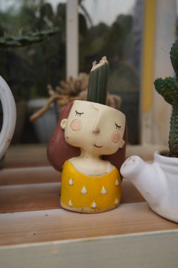 Bitki konteynırıyla küçük şirin bir sepetçi kızın yakın plan fotoğrafı.