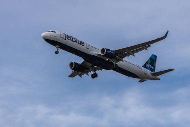 Boston 'a inmeye hazırlanan bulutlu bir gökyüzüne karşı JetBlue uçağı