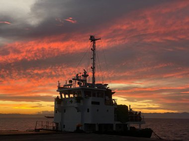 Semirara Adası, Caluya, Antika, Filipinler 'de beyaz bir kayıkla okyanusun üzerinde gün doğumu.