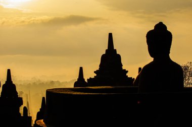 Bir Buda silueti ve günbatımında tapınaklar.
