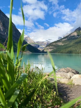 Arka planda dağlar olan büyüleyici bir göl manzarası.