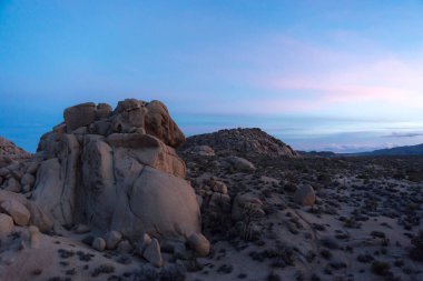 Kuru bir alanda bulutlu bir gökyüzüne karşı kayaların oluşumunun manzarası.