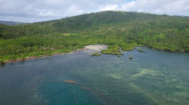 Filipinler 'de mavi bulutlu bir gökyüzünün altında güzel bir tropikal adanın insansız hava aracı görüntüsü