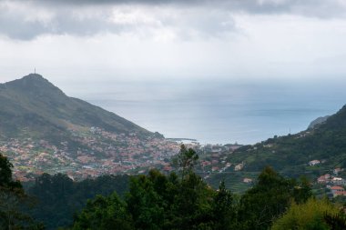 Bulutlu bir havada vadinin yanındaki bir kasabanın hava görüntüsü..