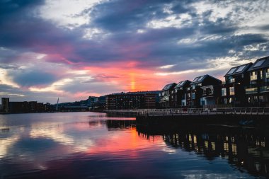 Gün batımında, Pembe gökyüzü ve Swansea ile su yüzeyine çarpıcı bir manzara yansıdı.