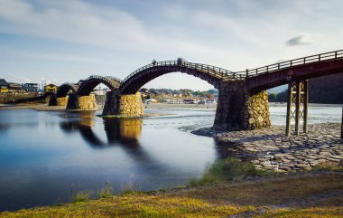 Gündüz vakti nehirde yansıyan eski bir köprünün güzel bir görüntüsü..