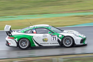 Islak yolda yarış arabası, yağmurlu bir günde. Porsche 911 Kupası 2017