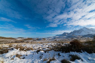 Arkaplanda karlı vadinin, dağların ve gökyüzünün güzel manzarası.