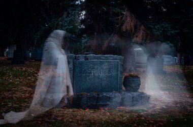 The ghosts roam near the gravestones in the cemetery. clipart
