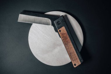 Cep çakısı. Fotoğrafı kapat. Plastik ya da ahşap saplı katlanabilir bir çakı. Paslanmaz çelik ordu ya da özel kuvvetler bıçağı. Her gün taşı