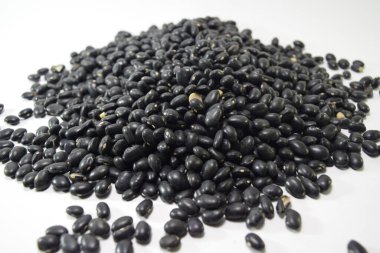 Beyaz bir yüzey üzerinde küçük siyah fasulye yığınına yakın çekim